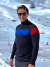 Man wearing a black sweater with blue and red stripes in a snowy landscape