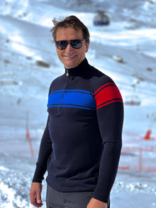  Man wearing a black sweater with blue and red stripes in a snowy landscape