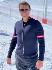  Man wearing a navy blue jacket with red stripes on sleeves in a snowy landscape