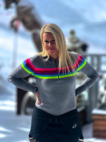  Person wearing a gray sweater with colorful stripes in a snowy outdoor setting