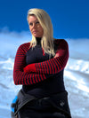 Woman wearing a red and black striped sweater with a blue background