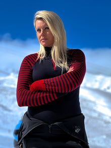  Woman wearing a red and black striped sweater with a blue background