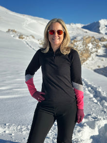  model wears a charcoal ski jumper with pink and grey cuffs.