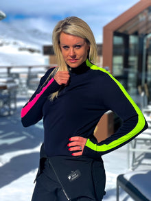  Person wearing a black jacket with pink and green accents outdoors