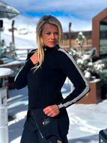  Person wearing a black outfit with white accents in a snowy outdoor setting